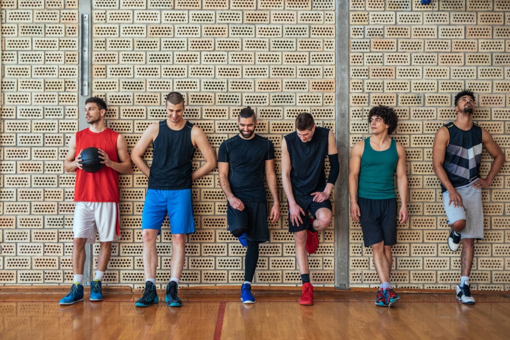 Team of players lined up against a gym wall before practice, representing a club uniform order